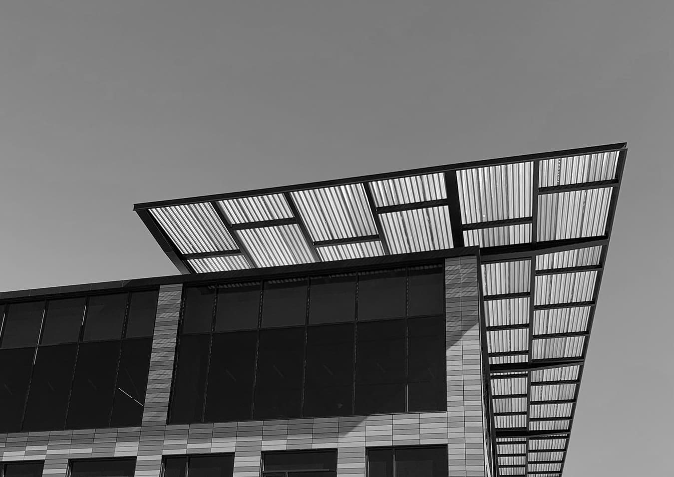 Black-and-white photograph of a cantilevered roof canopy on a modern building